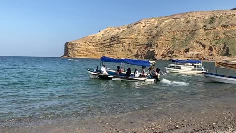 a young boatman drove the shuttle boat to carry tourists off qantab beach on a sunny day