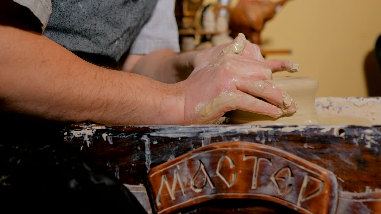 un alfarero profesional que trabaja con arcilla en la rueda del alfarero