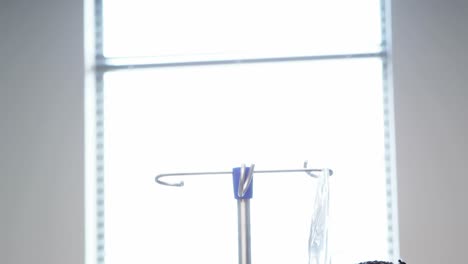 portrait of sick girl holding iv drip stand