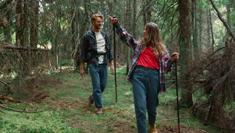 tourists hiking in fairytale forest. girl and guy walking between trees