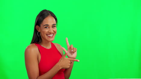 mujer feliz, sonriendo y apuntando a la pantalla verde