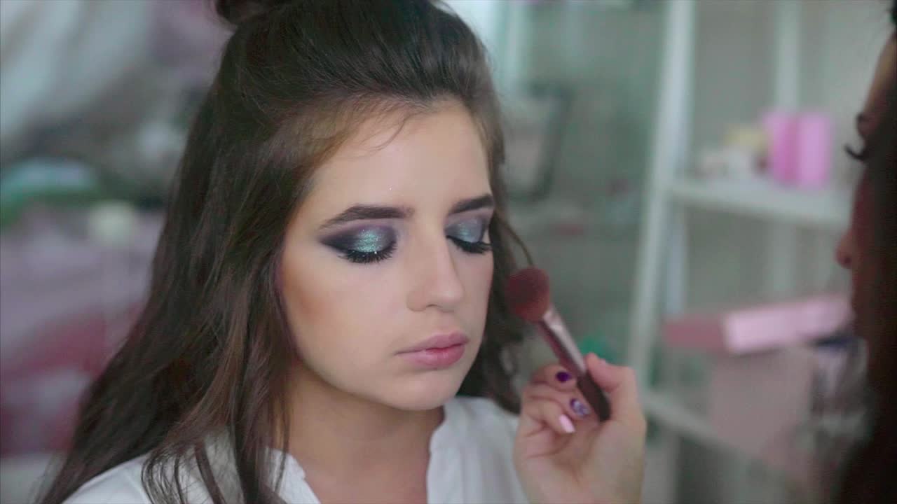 mujer haciendo maquillaje y cabello por un maquillador profesional