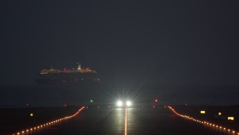 despegue nocturno de un avión contra el fondo de un crucero que pasa