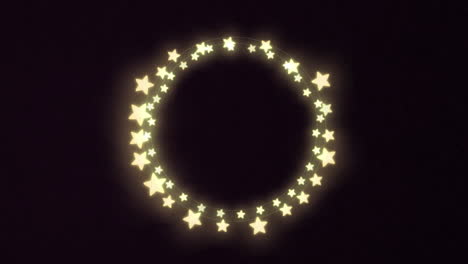 luces de hadas decorativas en forma de estrella brillante amarilla contra un fondo negro