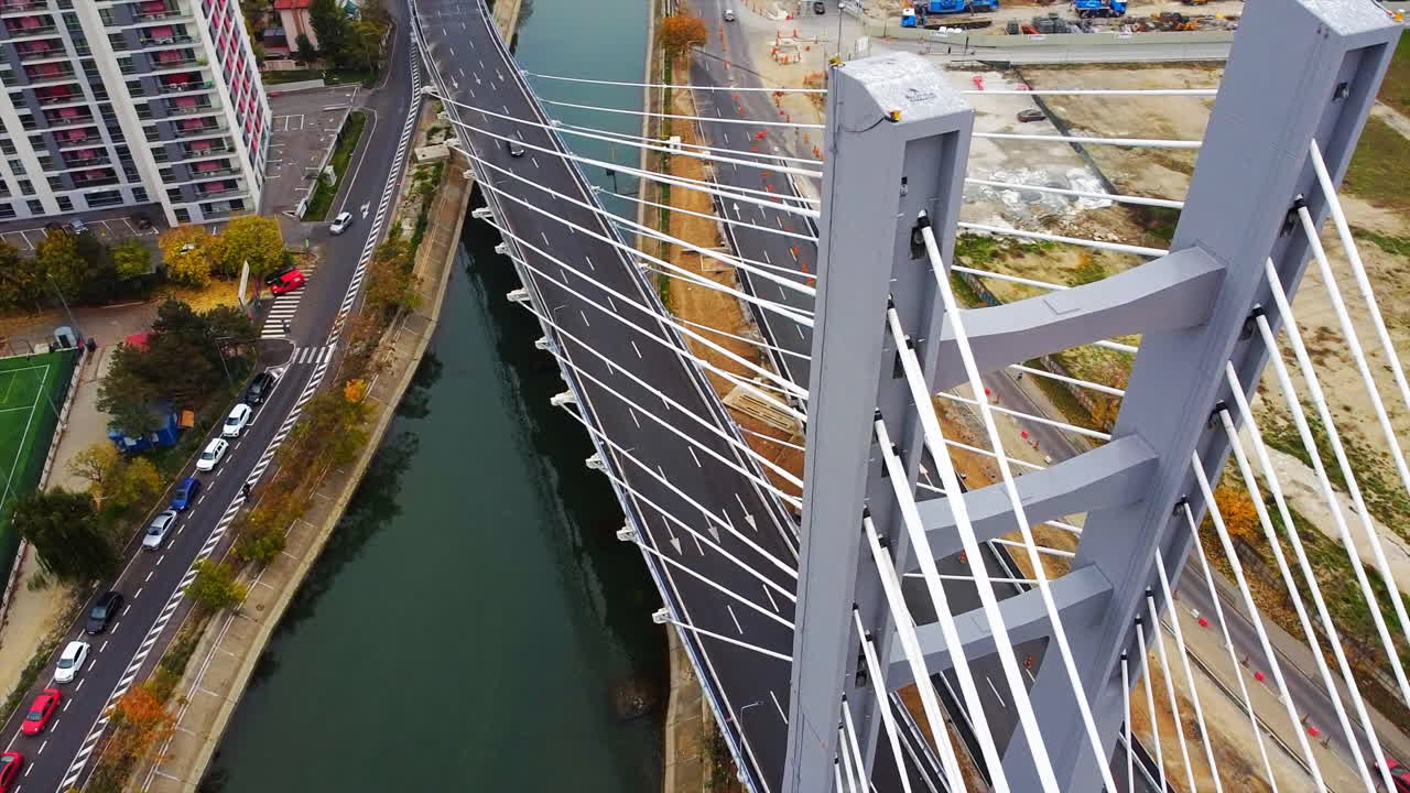 Ciurel passage, bridge over a river with moving cars, construction works near it. View from the drone. Bucharest, Romania