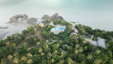 aerial view of a tropical island resort with a unique pool design