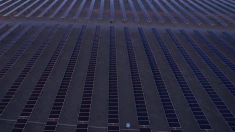 flying above arrays of solar panels in big solar power plant, drone shot