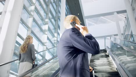 businessman moving upstairs on escalator in the office 4k