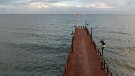 embarcadero de madera en el mar mediterráneo con gente caminando sobre él