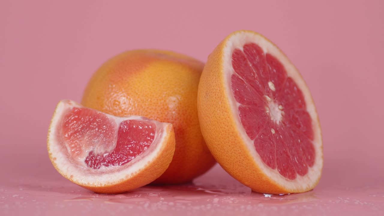 Pieces of ripe grapefruit slowly rotate.