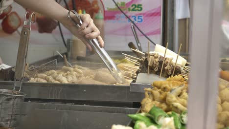 vendor tends street food stall in hong kong