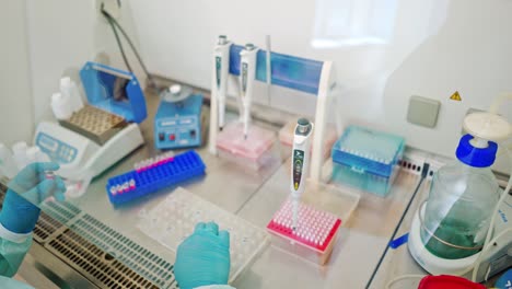 close-up work of medical scientist with test tubes on sterile table. hands in protective gloves of female assistant working with plastic vials in the laboratory.