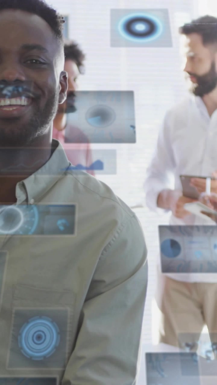Vertical video: Man in mint shirt smiling as team tapping tablet making tech tiles over face demo