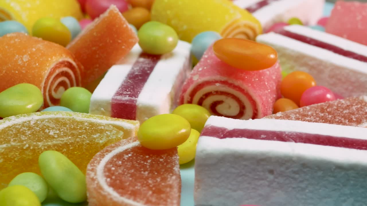 el enfoque suave de la mermelada de naranja y limón, el malvavisco de vainilla, los dulces multicolores mixtos están girando. dulces para niños
