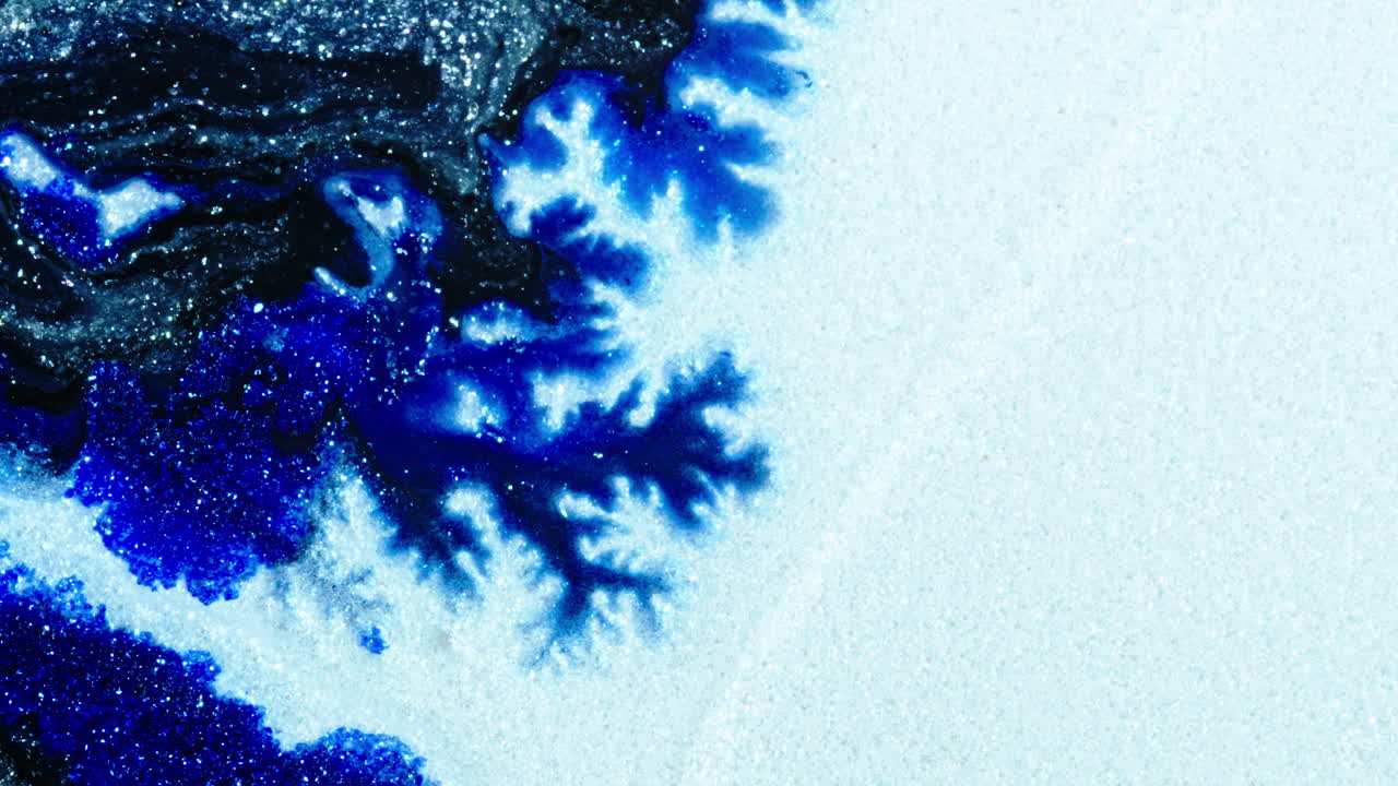 Substances mixing in a colorful pattern, showcasing a macro shot with fluid dynamics