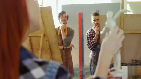 teacher holding figurine while interacting with artist 4k