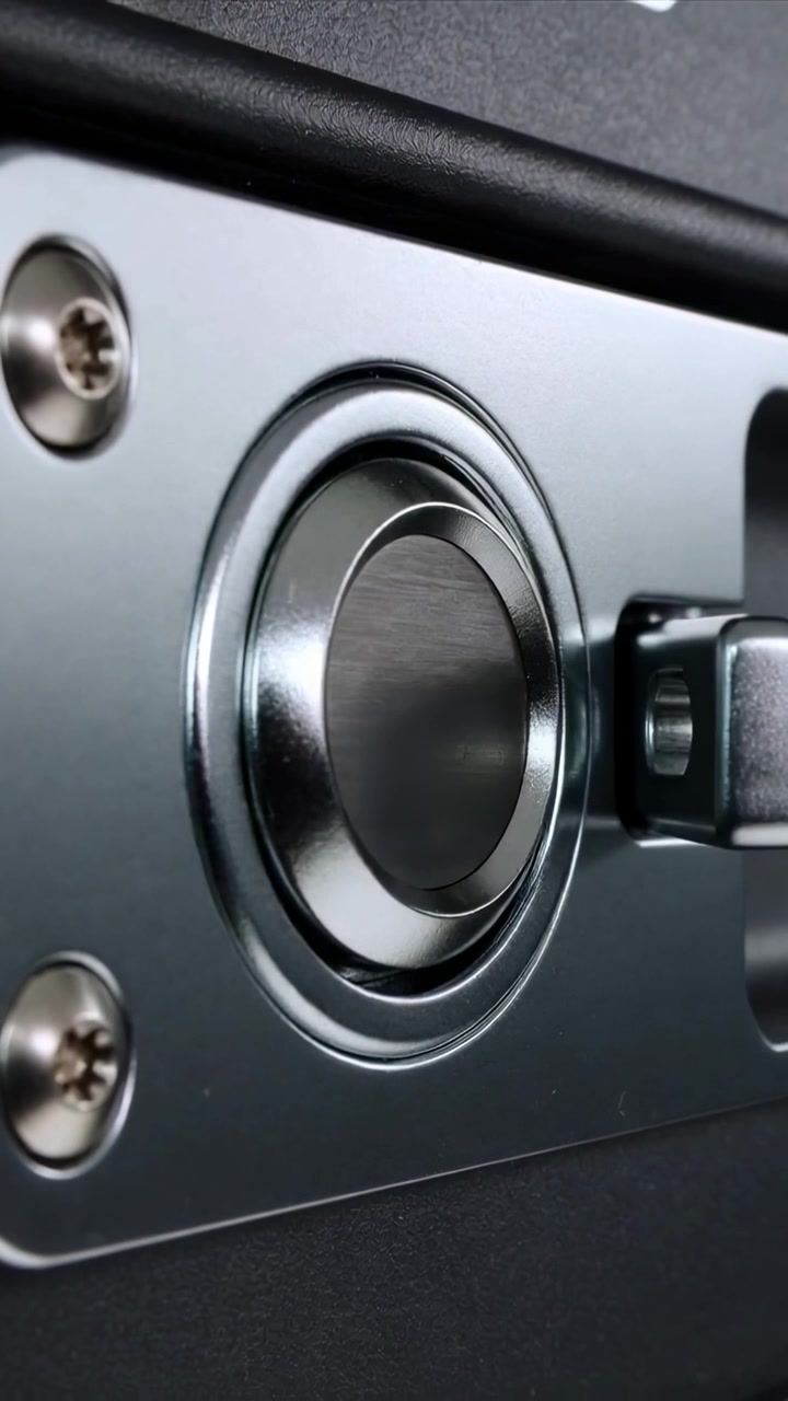 Vídeo vertical: Recebendo pressão, botão girando e deslizando para dentro em placa de metal com trinco.