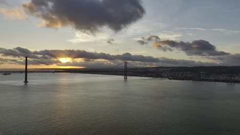 fotografía de un avión no tripulado que se levanta desde almada, río tangus, con vista sobre el puente "ponte 25 abril", al atardecer