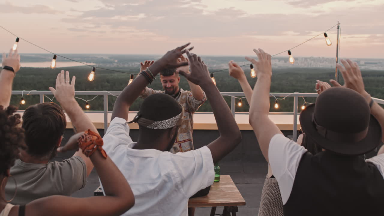 Happy People Dancing at Rooftop Party with DJ