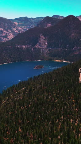 splendid mountainous landscape with pine trees growing on. azure of lake tahoe at the foot of rocks. aerial view. vertical video