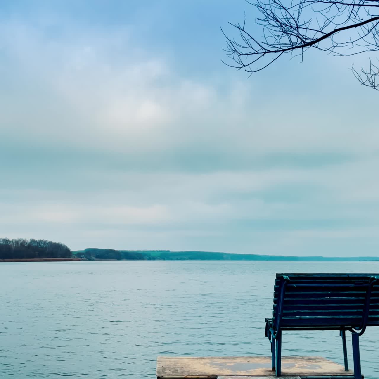 Wooden deckchair on the little footbridge on the calm river. Meditative place for calm time-spending in the nature