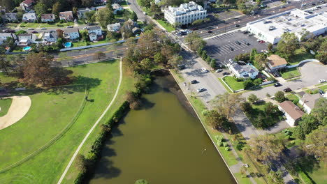 An-aerial-shot-of-a-green-pond-in-a-suburban-neighborhood-on-Long-Island,-NY