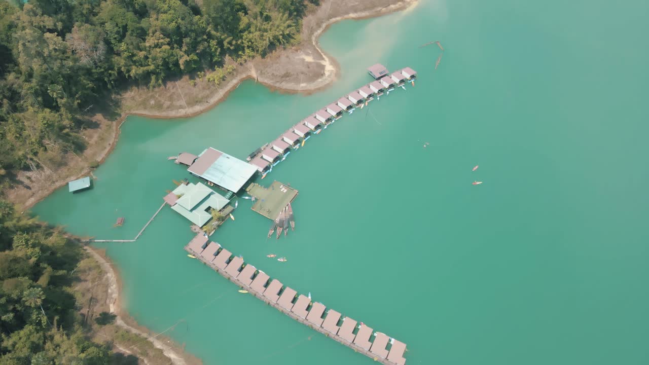 increíbles imágenes de aviones no tripulados de varias personas en kayak junto a los bungalows flotantes en el parque nacional khao sok de tailandia
