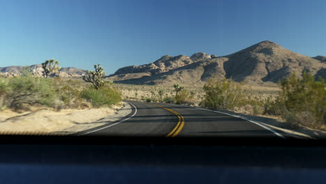 guidare durante il tramonto nel deserto del parco nazionale di joshua tree