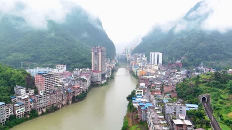 Antena-Panorámica-De-La-Ciudad-De-Yunnan,-Condado-De-Yanjin-Desde-El-Río,-Edificios-De-Apartamentos-Y-Casas-Chinas