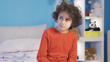 un niño infeliz llorando en su habitación.