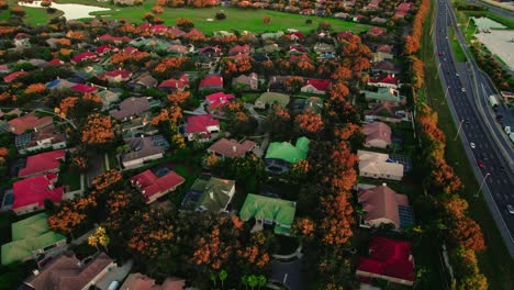 Aerial-drone's-forward-view-over-town-with-a-high-speed-road-next-to-it