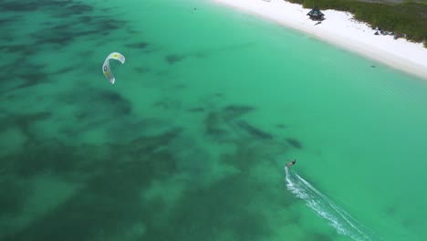 Kitesurfer-gliding-across-turquoise-waters-near-Crasky-beach-in-Los-Roques,-aerial-view