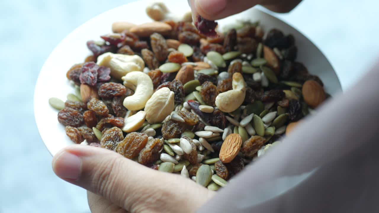 손으로 가까이에서 혼합 된 견과류를 뽑으십시오.