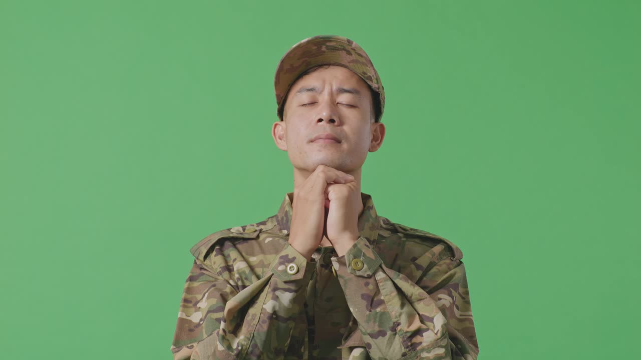 Close Up Of Asian Man Army Soldier Uniform Praying In The Green Screen Background Studio