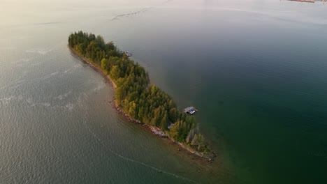Aerial-golden-hour-orbit-of-small-island-sunset-reveal,-Lake-Huron,-Les-Cheneaux-Islands,-Michigan