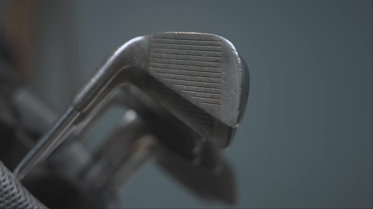 close-up shot of golf clubs being remove from a golf bag to play a shot