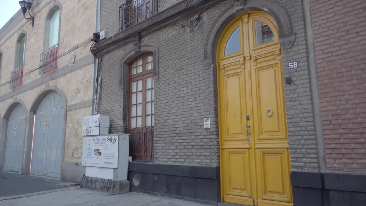 Yellow Door on a Brick Building in a City Street