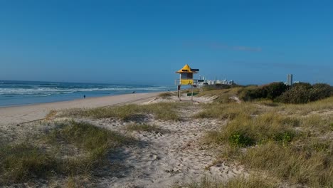 Ein-Rettungsturm-In-Den-Sanddünen-In-Der-Nähe-Einer-Geschäftigen-Stadt