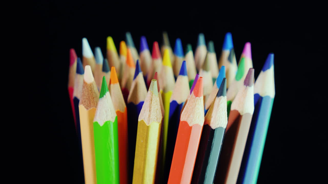 un juego de lápices multicolores sobre un fondo negro