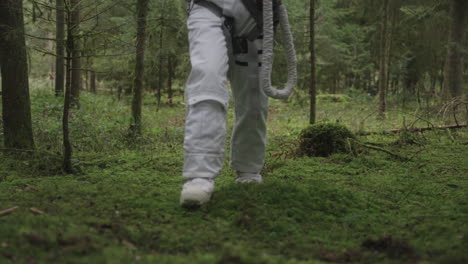 Astronaut-in-space-suit-walking-trough-forest