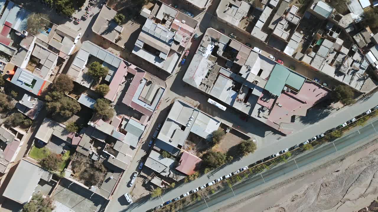 The picturesque town of Purmamarca seen from above by a drone, showcasing its narrow sandy streets.