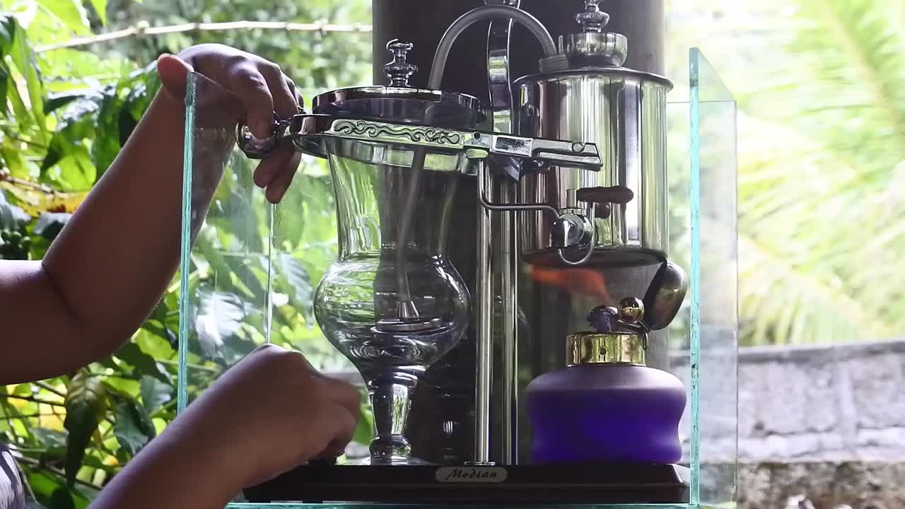 ⁇ 는 스토브를 가열하여 시베트 커피를 준비하는 손의 클로즈업  ⁇