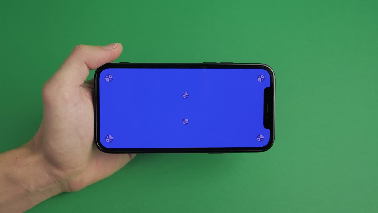 수평 블루 스크린 크로마 키를 가진 드폰을 들고 있는 남자 손의 클로즈업 스마트폰 기술 셀 폰 터치 메시지 디스플레이 손이 녹색 스크린 배경에