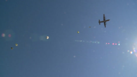 ground angle view of paratroopers parachuting to earth