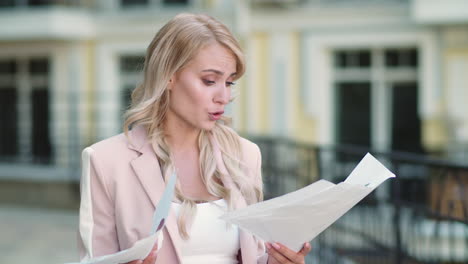 Closeup-woman-analyzing-papers-outdoor.-Woman-reading-statistics-at-street