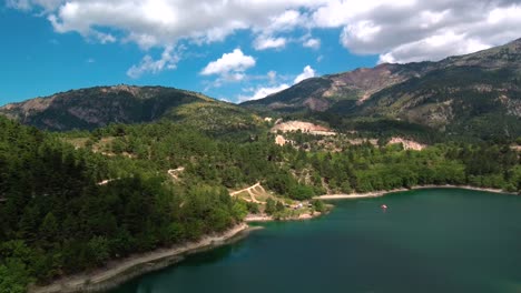 aerial parallax shot of lake tsivlou with mountains surrounding peacefully the natural waters on an overcast cloudy day