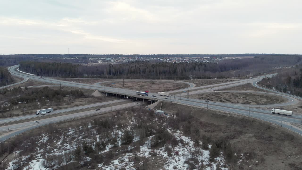 автомобильный перекресток с мостом на облачном весеннем вечере в лесу