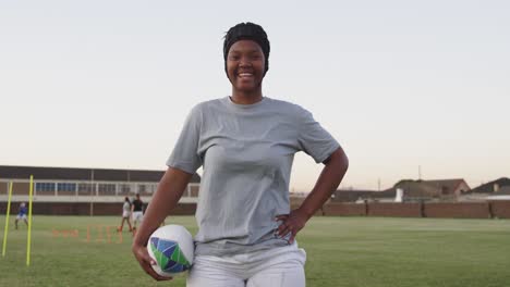 portrait of young adult female rugby player on a rugby pitch