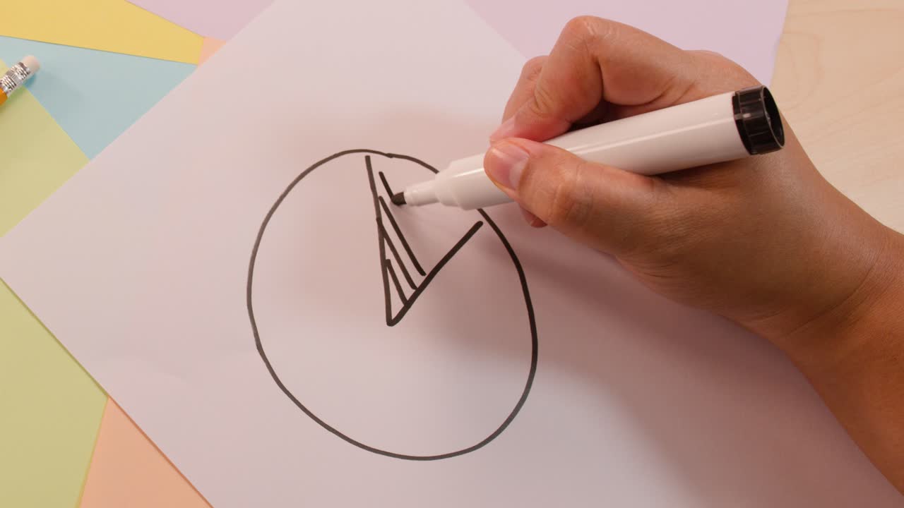 Person draws and shades pie chart segment, labels with symbols, top-down view, soft lighting