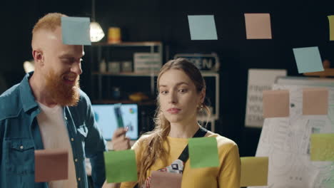 mujer de negocios y colega analizando notas de lluvia de ideas en una oficina hipster.